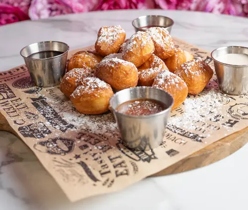 Powdered sugar beignets with dipping sauces
